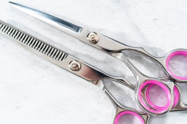 Gri arkaplanda yeni berber pembe makas.