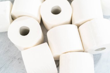 Gri arka planda yeni beyaz tuvalet kağıdı ruloları.