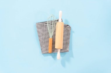 Düz yatıyordu. Mavi arka planda ahşap saplı yeni mavi silikon mutfak aletleri..