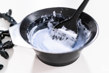 Saç rengini siyah bir kaseyle fırçayla karıştırıyorum..