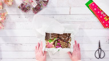 Düz yatıyordu. Adım adım. Ev yapımı şekerleme ve kurabiyeleri Noel hediyesi kutusuna koymak.