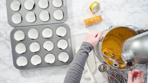 Düz yatıyordu. Balkabağı aromalı kek hamuru. Hamur hamuru kepçesiyle kapkek tepsisine dolgu malzemesi..