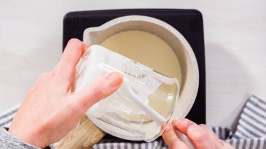 Adım adım. Düz yatıyordu. Elektrikli bir tavanın üzerinde küçük bir tencereyle çikolata kreması hazırlıyorum..