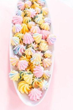 Beyaz servis tabağında çok renkli tek boynuzlu at kurabiyeleri..