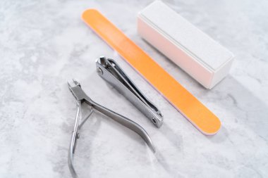 Tırnak törpüsü, tırnak törpüsü, tırnak törpüsü, tırnak törpüsü ve tezgahta tırnak yağı olan basit bir manikür aleti..