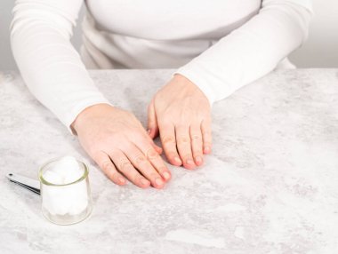 Kadın manikürünü evde basit manikür aletleriyle bitiriyor..