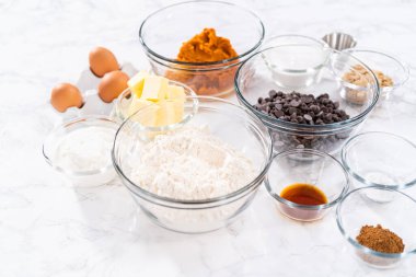 Çikolata kabaklı kek pişirmek için bardaktaki ölçülü malzemeler..