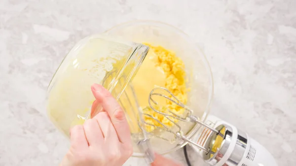 Flat lay. Step by step. Mixing ingredients in a glass mixing bowl to bake funfettti bundt cake.