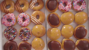 Beyaz bir karton kutuda mağazadan alınmış donutların çeşitliliği.