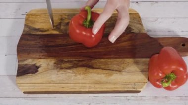 Ağaç kesme tahtasındaki organik kırmızı dolma biberler..