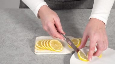 Beyaz tabakta organik limon dilimleri dilimliyorum..
