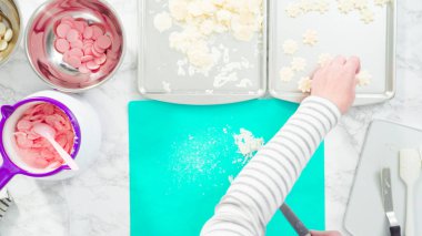 Düz yatıyordu. Adım adım. Fazla çikolatayı, kar taneleri şeklindeki çikolatalardan küçük bir mutfak bıçağıyla budamak..