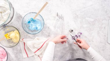 Düz yatıyordu. Adım adım. Tek boynuzlu at meringue kurabiyesi pişirmek için metal uçlu boru torbalarına krema karıştırılıyor..