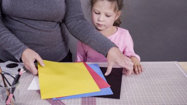 İnşaat kağıdından el yapımı Babalar Günü kartı yapan küçük bir kız..