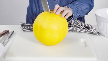 Adım adım. Beyaz arka planda altın rengi çiğ taneli kavun.