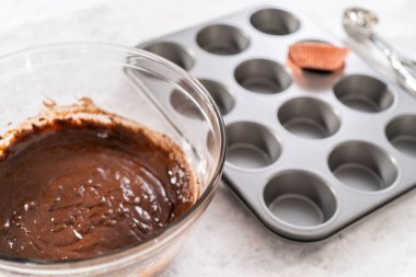 Çikolatalı çilekli kek pişirmek için kek hamurunu kek kaplarının içine atıyoruz..