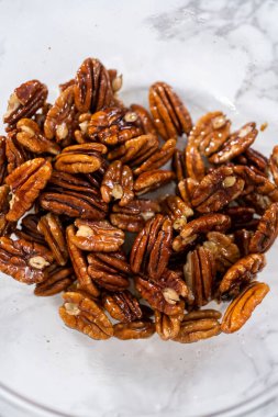 Kavrulmuş ceviz yapmak için büyük bir bardakta karışımı karıştırıyorum..