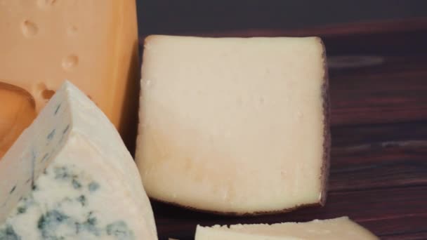 深色木制背景上的各种大型美味奶酪楔子 — 图库视频影像