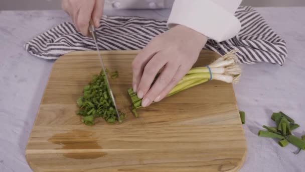 Biologische Groene Uien Snijden Een Houtsnijplank — Stockvideo