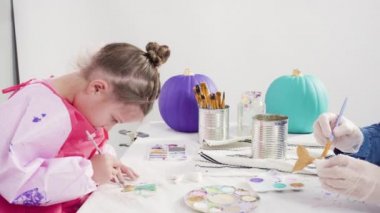 Süslü deniz kızı Cadılar Bayramı balkabağı yaratmak için akrilik boyalı balkabağı boyamak.