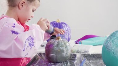 Süslü deniz kızı Cadılar Bayramı balkabağı yaratmak için akrilik boyalı balkabağı boyamak.