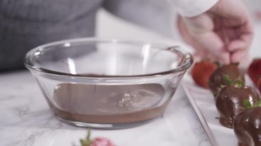 Çikolata kaplı çilekleri kurabiye tepsisinde hazırlıyorum..