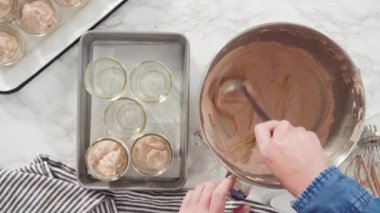 Ev yapımı çikolatalı dondurma yapmak için küçük cam kavanozlara karıştırıyorum..