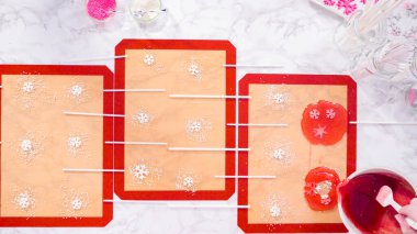 Düz yatıyordu. Ev yapımı lolipoplar yapmak için silikon paspaslara karamelize şeker dökmek..