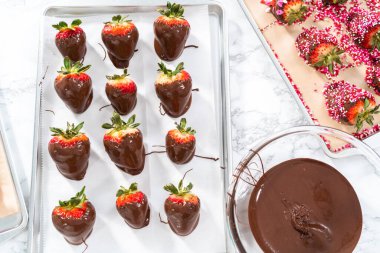 Çikolata kaplı çilekleri kurabiye tepsisinde hazırlıyorum..