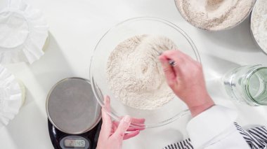 Düz yatıyordu. Tarçınlı rulo pişirmek için cam bir kasenin içindekileri ölçüyorum..