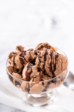 Ev yapımı çikolata parçalı dondurmayı cam bir kasede çikolatayla servis ediyorum..