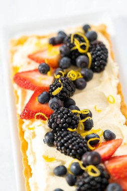 Manzarayı kapat. Taze böğürtlenli ve limonlu taze mascarpone turtası..