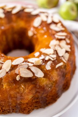 Beyaz tabakta karamel jöleli taze pişmiş elmalı kek..
