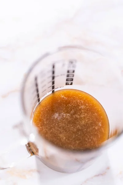 Homemade Caramel Glaze Bundt Cake Cooling Glass Measuring Cup — Stock Photo, Image