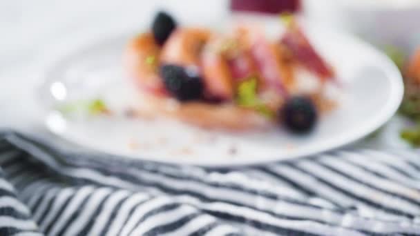 用黑莓装饰在白盘上的桃红面包 — 图库视频影像