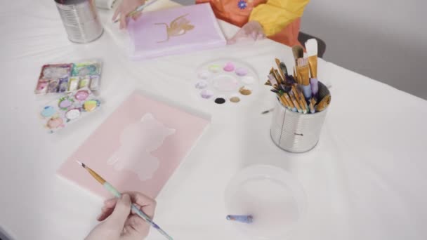遠くの学習アートプロジェクトのための彼女の母親とキャンバス上のアクリル絵具と女の子の絵 — ストック動画