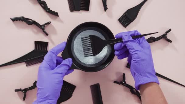 粉色背景的黑色塑料搅拌碗中的发色染料粉末 — 图库视频影像