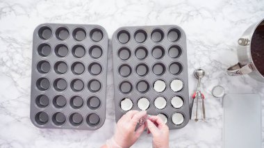 Düz yatıyordu. Adım adım. Mini çikolatalı kek pişirmek için kek kalıplarıyla kek tepsisi hazırlıyorum..