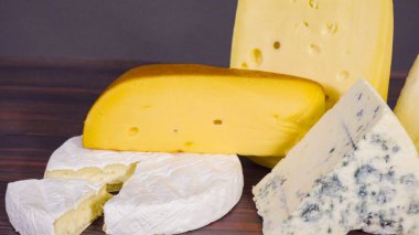 Kaba ahşap arka planda büyük gurme peynirleri..