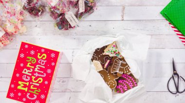 Düz yatıyordu. Adım adım. Ev yapımı şekerleme ve kurabiyeleri Noel hediyesi kutusuna koymak.