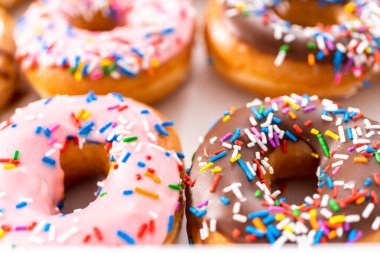Beyaz bir karton kutuda mağazadan alınmış donutların çeşitliliği.