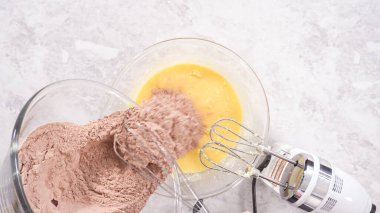 Düz yatıyordu. Adım adım. Kırmızı kadife kek hazırlamak için karıştırma kabındaki malzemeleri karıştırıyorum..