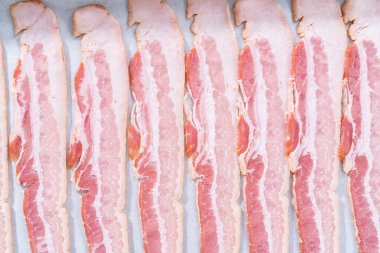 Pişmemiş pastırma şeritleri ve beyaz parşömen kağıtları..