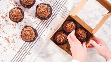 Düz yatıyordu. Adım adım. Çikolatalı kapkekleri çikolatalı ganache ile paketleyip kek kutusuna koymak..