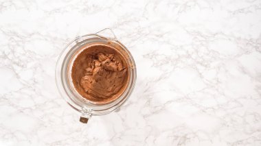 Düz yatıyordu. Adım adım. Elektrikli mutfak mikseriyle çikolatalı ganache çırpmak..