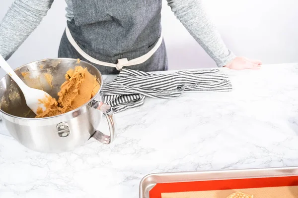 Mixing ingredients in standing kitchen mixer to bake peanut butter cookies.