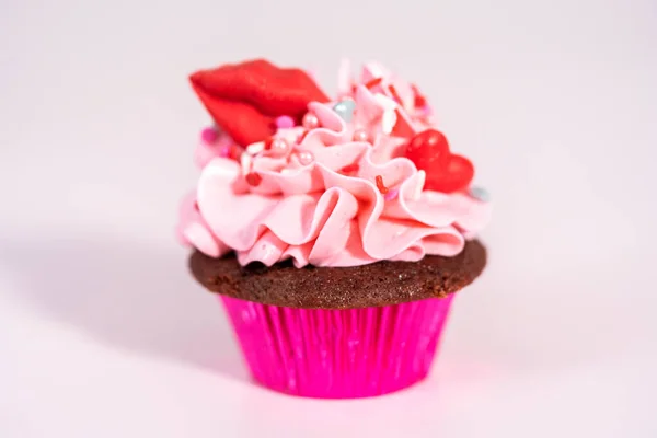 赤いベルベットのカップケーキピンクイタリアのバタークリームの霜降りとハートとキス形の赤いチョコレートで飾られています — ストック写真