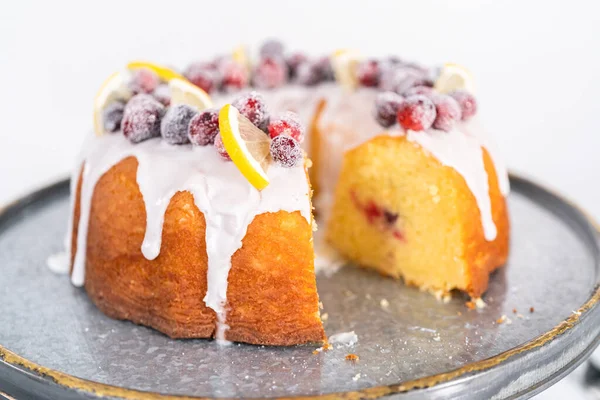 Dilimlenmiş limonlu kek. Şeker kızılcıkları ve limon dilimleri ile süslenmiş..