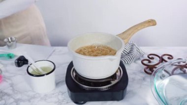 Küçük elektrikli ocağın üzerinde küçük bir tencerede karamelize şeker.