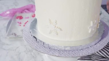 Adım adım. Yuvarlak funfetti pastasını pembe ve beyaz fondant kar taneleriyle süslüyorum..